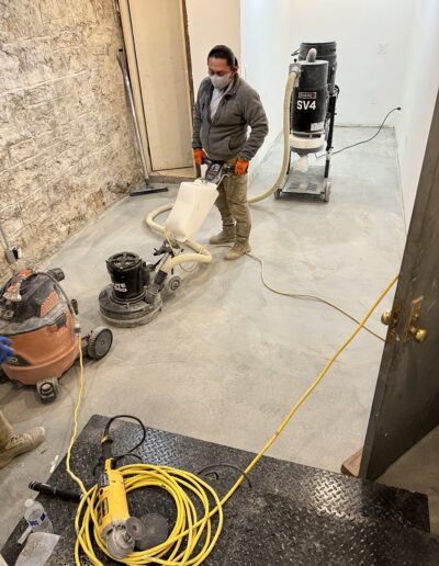 A man is using a power washer on the floor